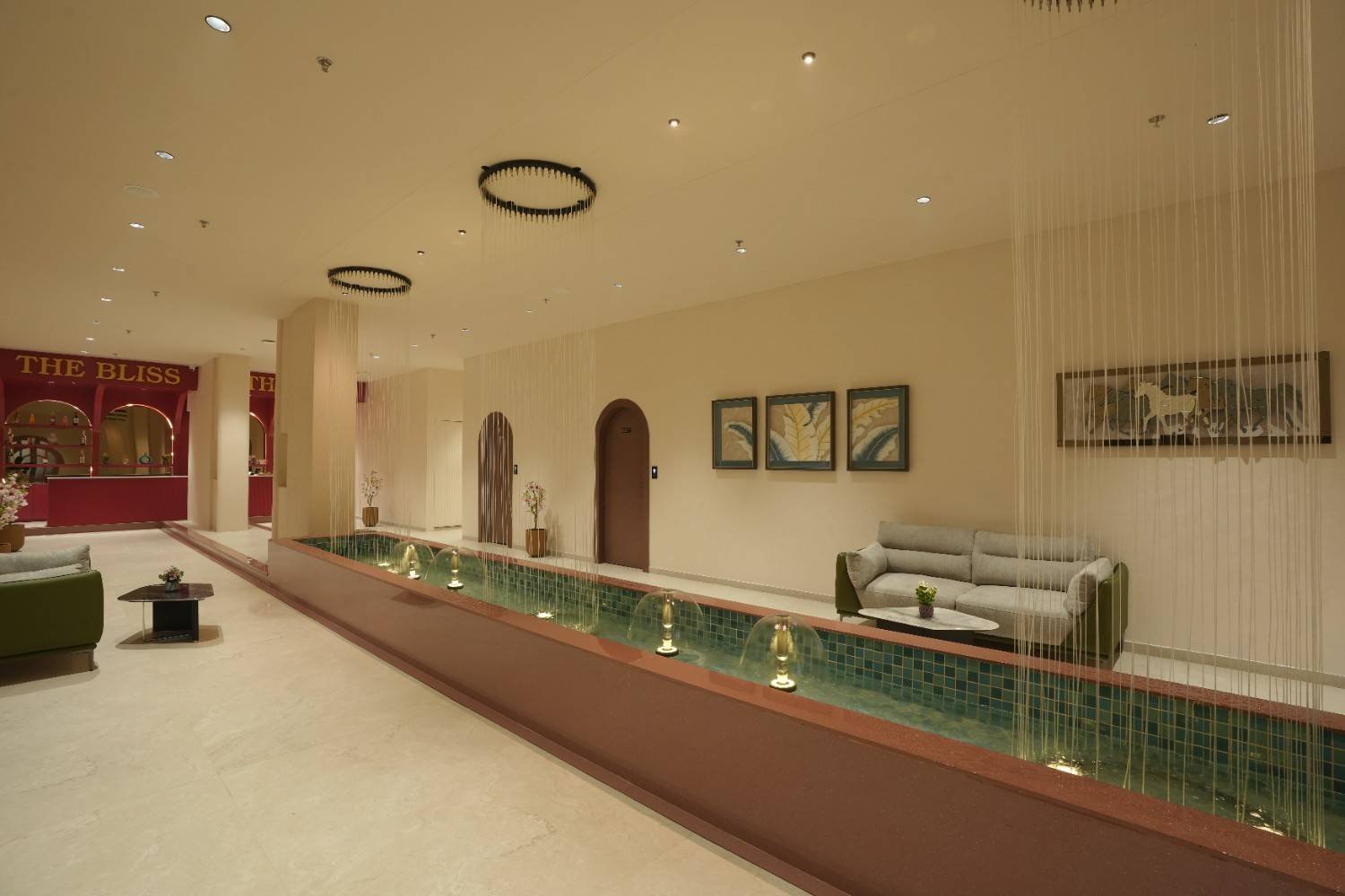 Serene spa hallway with water feature and red spa bar at The Bliss